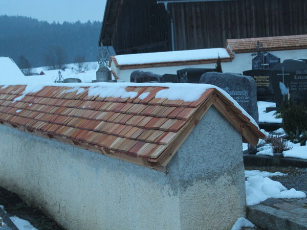 Mauerabdeckung mit Holzschindeln im Winter