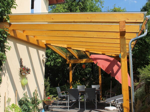 Terrassenüberdachung aus Holz mit Sitzbereich