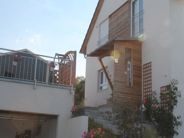 Wohnhaus mit Holzfassade und Balkon